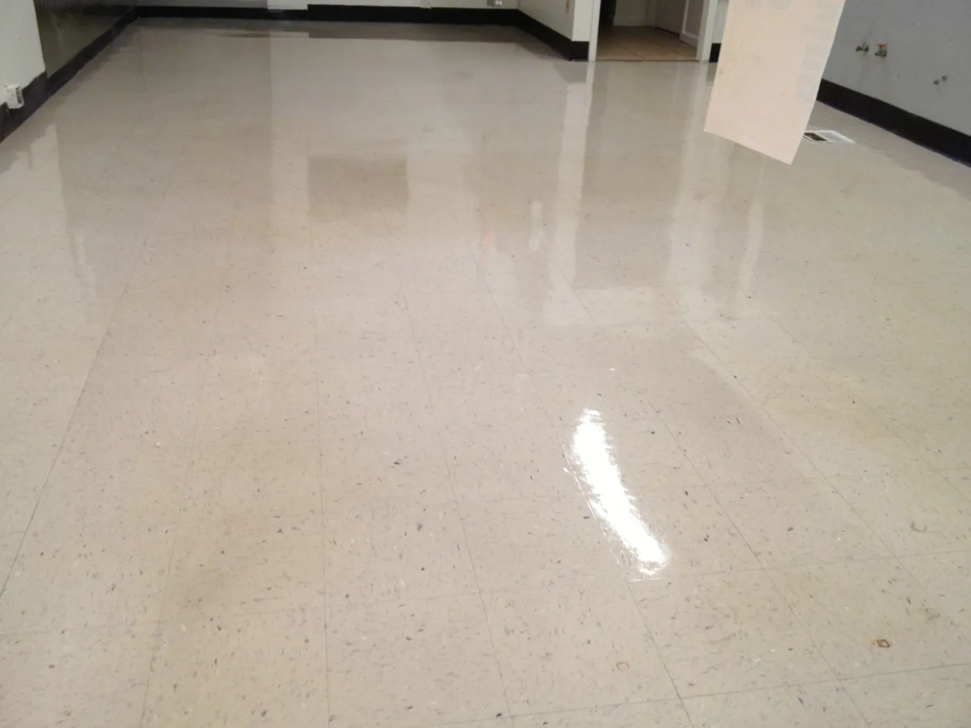 Stripped and waxed commercial hallway floor with a high-gloss finish